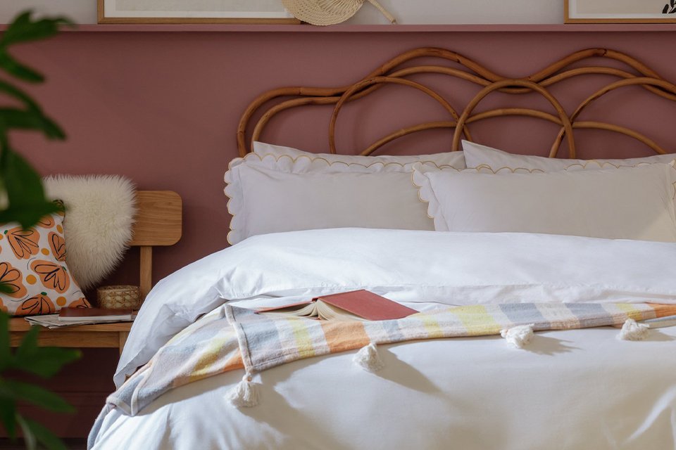Wooden framed bed with white bedding.