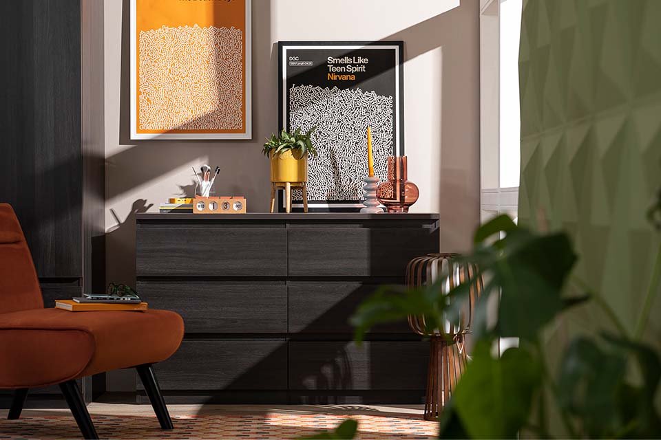 A charcoal coloured chest of drawers in a bedroom.