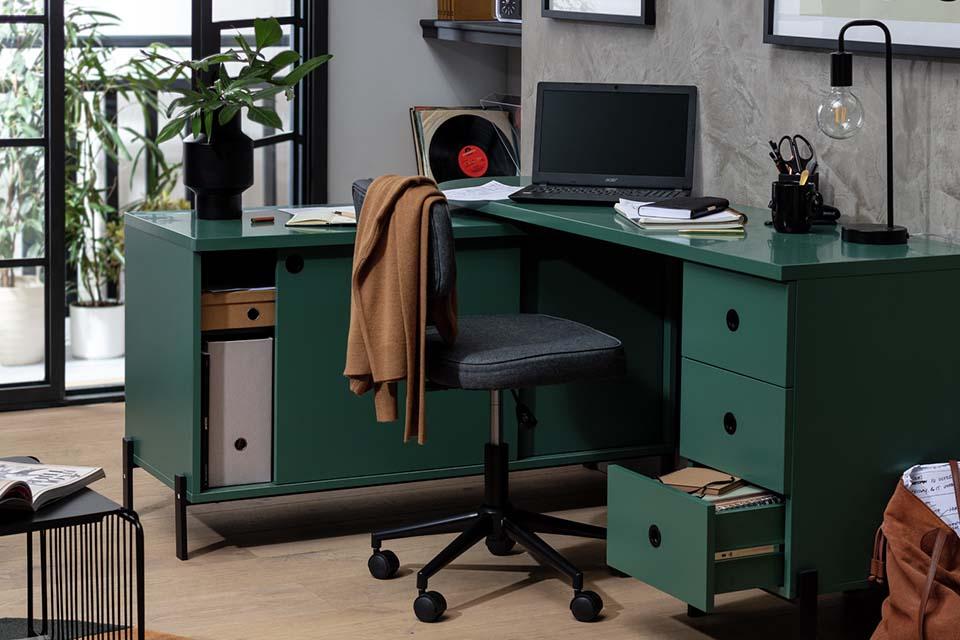 A green office desk with a grey office chair in a living room.