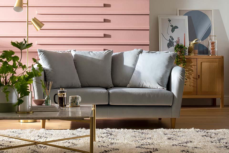 A contemporary living room interior with a grey chunky sofa and a coffee table.