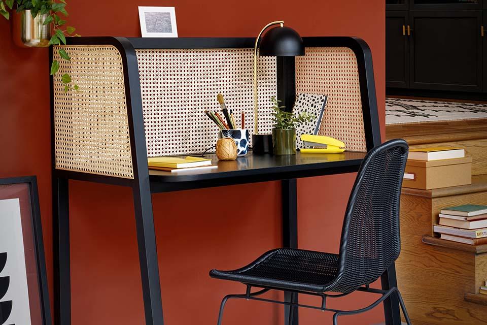 A compact home office with a black chair and a black table.