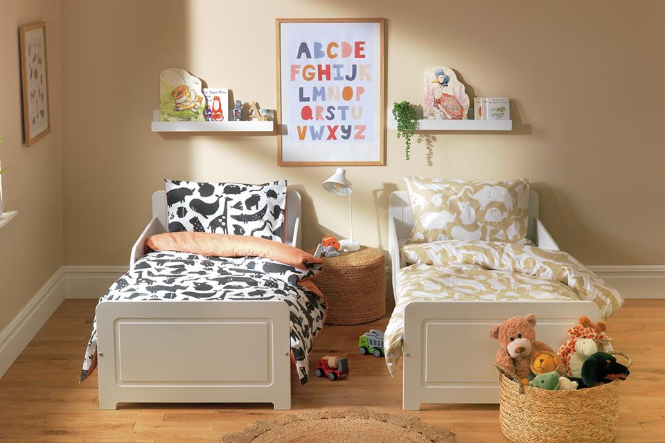 Twin toddler's bed in white with abstract animal print bedding.