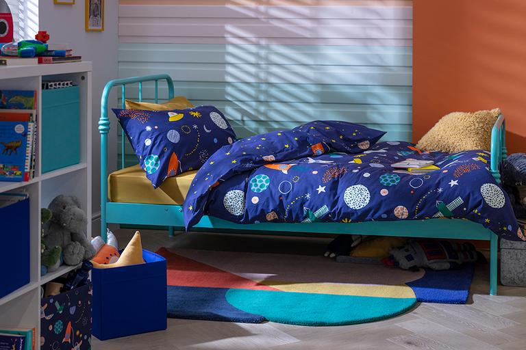A blue kid's bed with space print bedding.