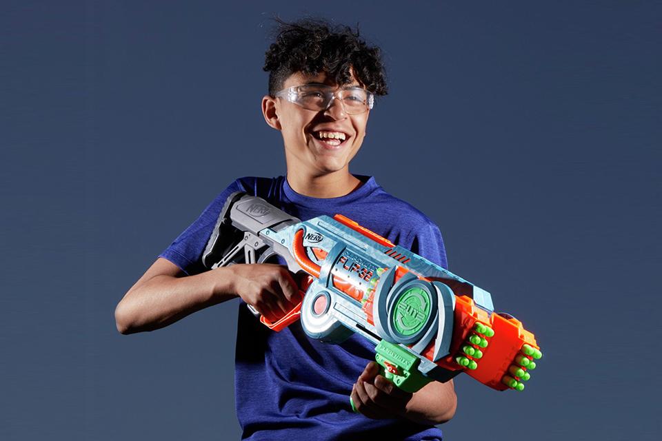 A boy holding a Nerf Elite 2.0 Flipshots Flip-32 Blaster.