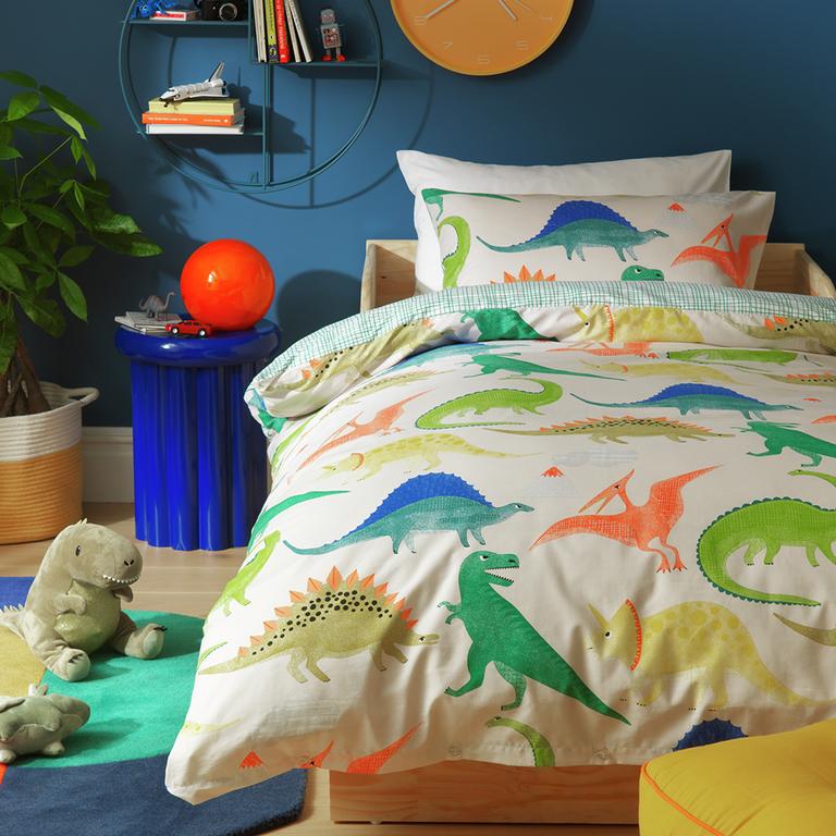 A dinosaur themed bedding in a kids room.