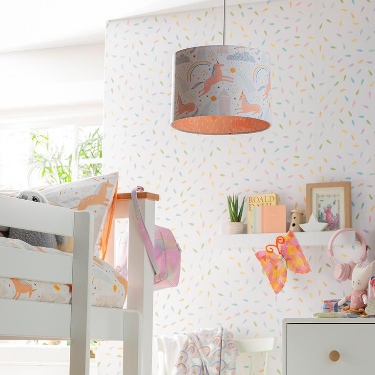 A unicorn print ceiling lamp and bedding in a kids bedroom.