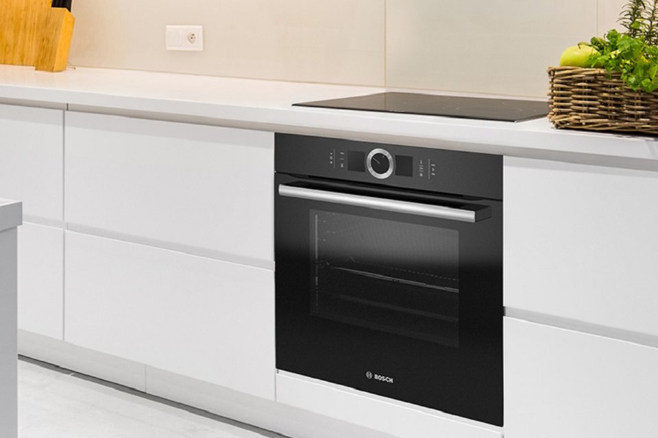 A Bosch built-in single electric oven and an induction hob integrated into a modular kitchen. 