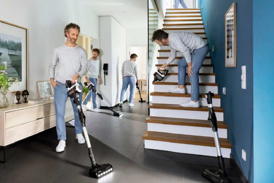 A man cleaning all the corners of his house with a Bosch Unlimited 6 cordless vacuum cleaner.