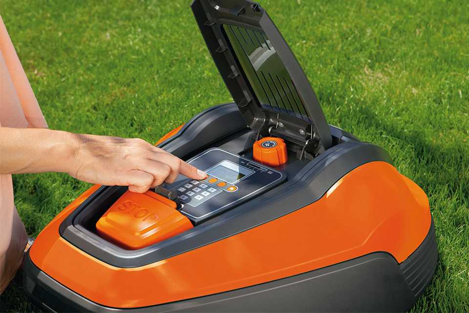 A person using a robotic lawn mower in the garden.