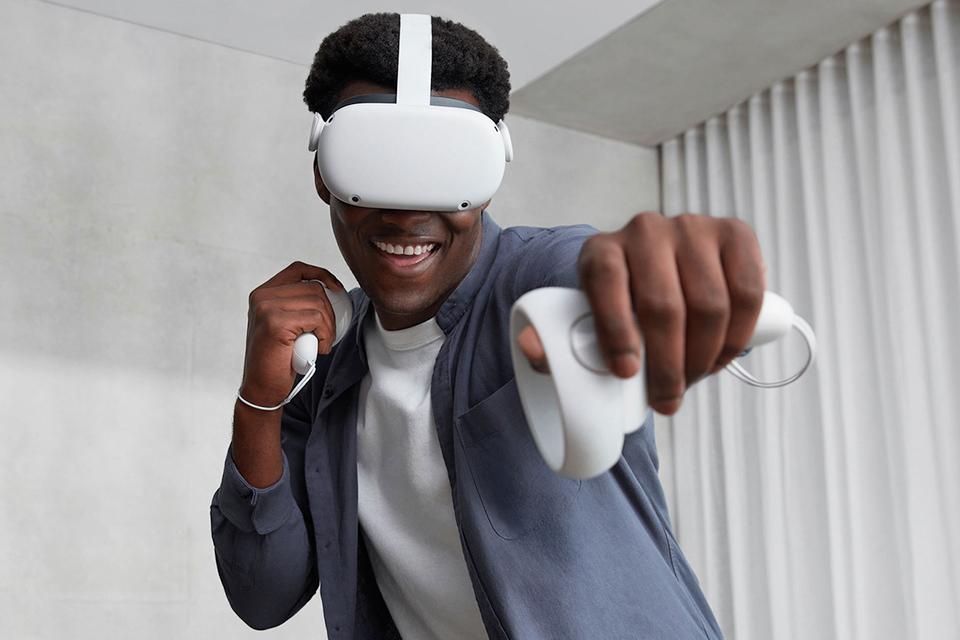 A man plays with the Oculus Quest 2 VR headset and Touch controllers.