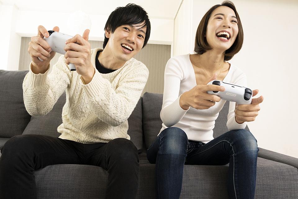 A young couple enjoy playing on the PS5 console.