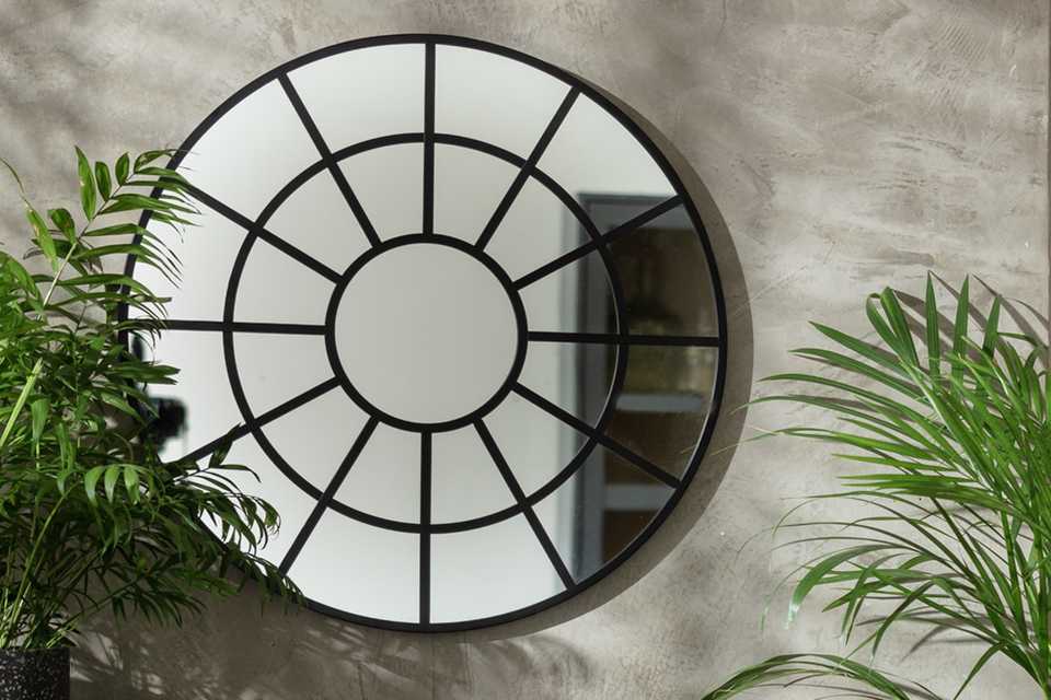 Circle wall mirror with black frame.