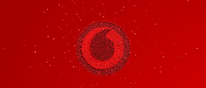 An ariel view of lots of bright red balloons appearing to create the Vodafone logo.