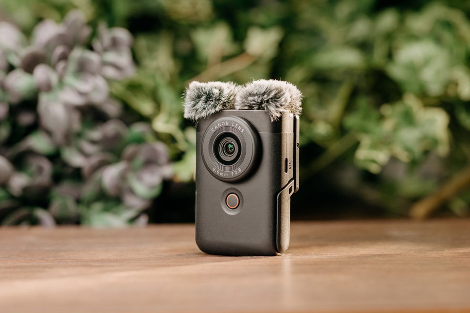 A Canon PowerShot V10 vlogging camera in frame. 