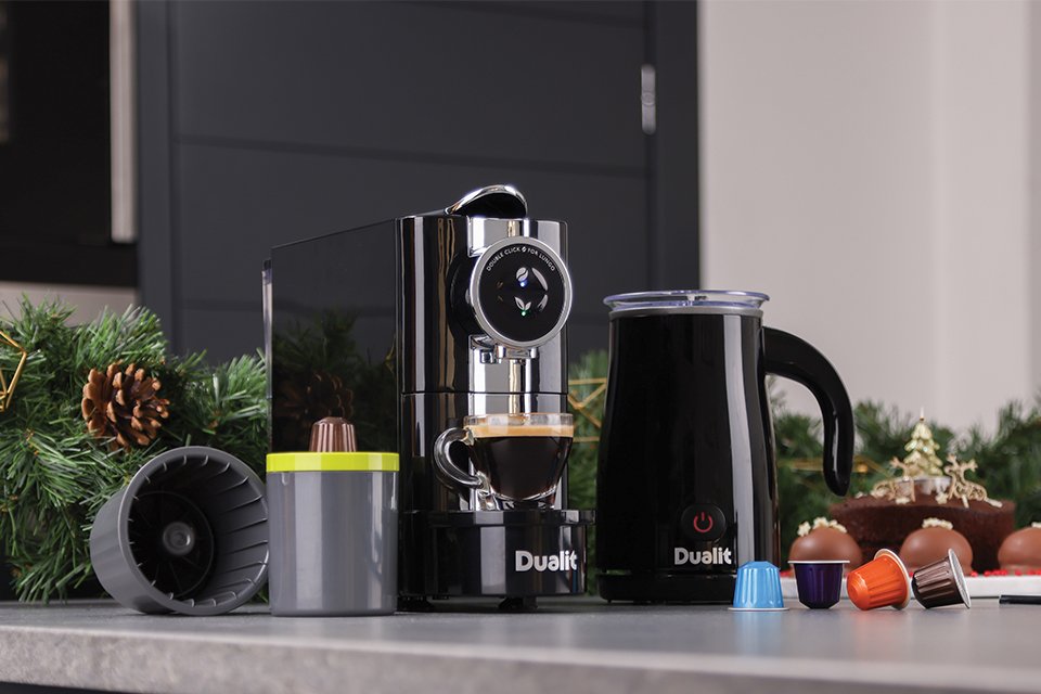 A Dualit Café Plus coffee machine, EcoPress™ capsule recycler and milk frother with coffee capsules.