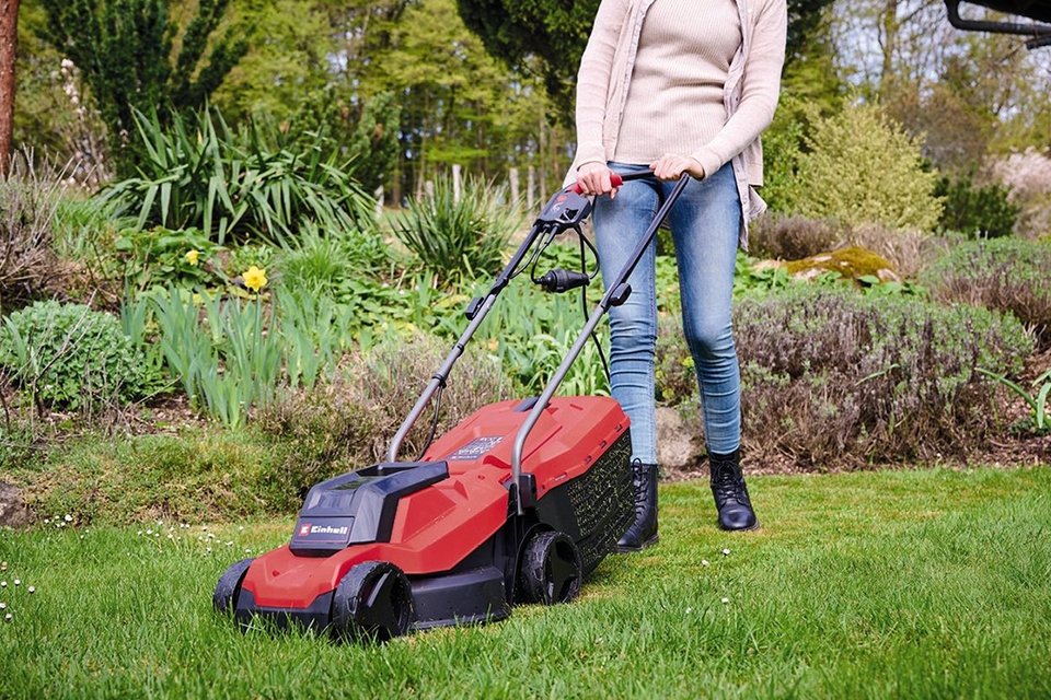  A person using Einhell 32cm Corded Rotary Lawnmowers.