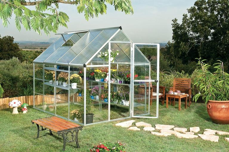 A canopia hybrid silver greenhouse in a garden.