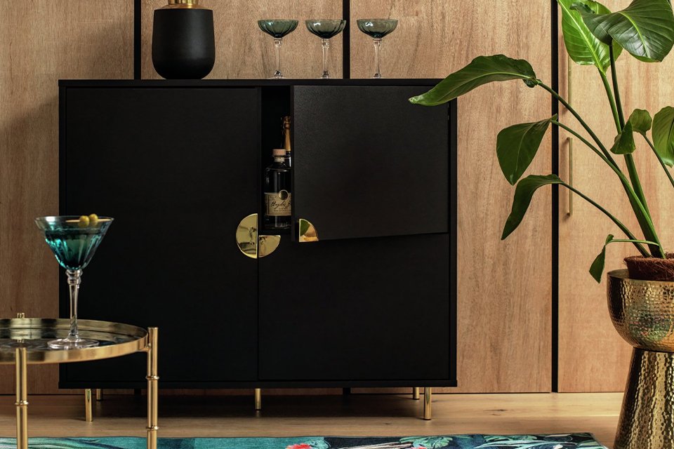 Black drinks sideboard with gold handle and accessories.