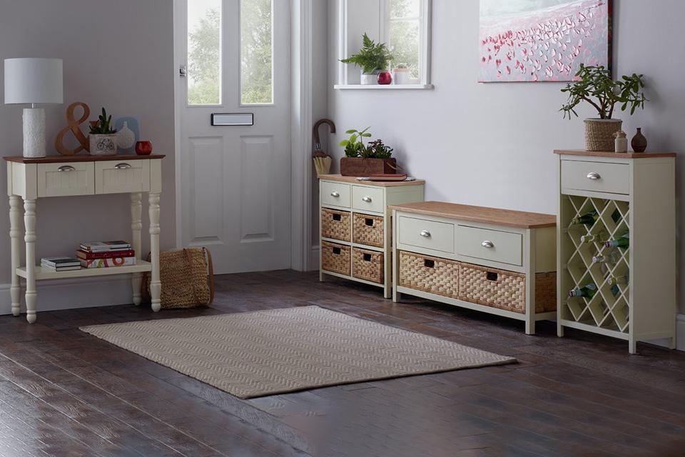 A collection of hallway furniture in cream and natural finish with home accessories displayed on them.