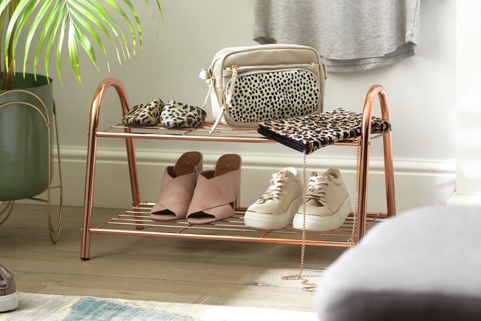 A copper finish wire shoe rack in a hallway.