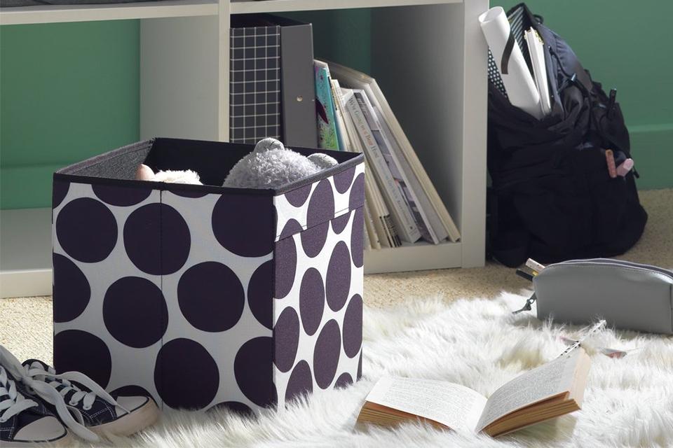 A set of 2 monochrome cube storage boxes in polka dot pattern with a white shelving unit.