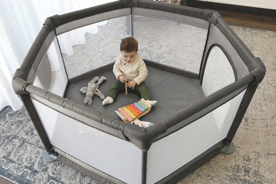 A baby playing in Dreambaby Explore Playpen Taupe.