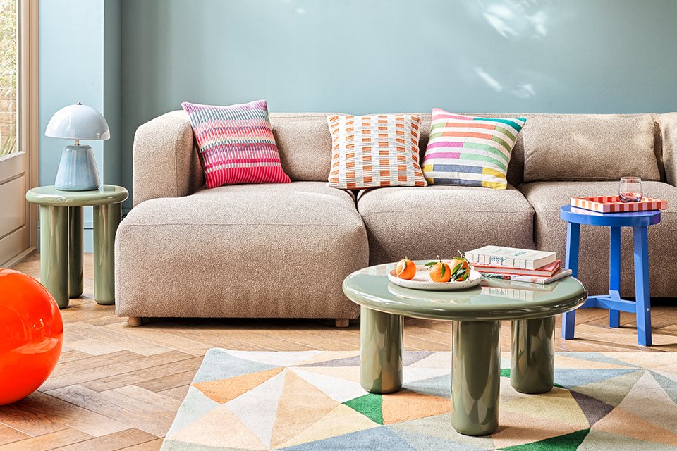 A Habitat sofa placed in a living room with multicoloured cushions on it. 