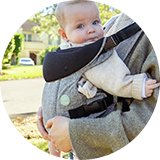 A baby in a Dreambaby Journey Baby Carrier (3 Way Facing) Grey.