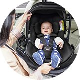 A baby in a Joie Signature i-Level Pro Deep Recline Car Seat - Eclipse.