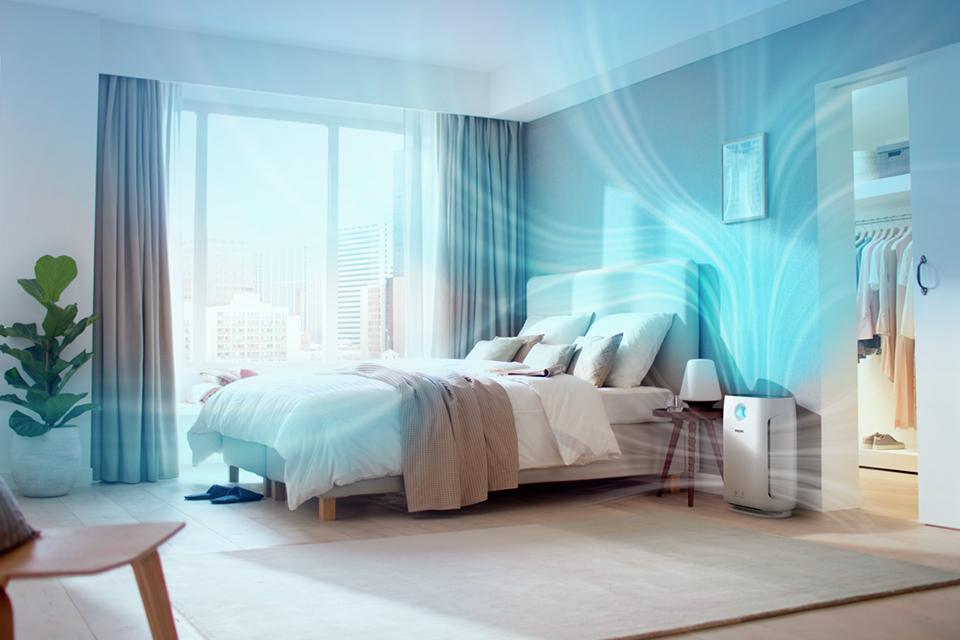 An air purifier in a bedroom with illustrative graphics.