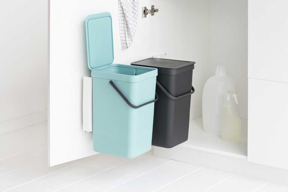 Image of a turquoise bin and a black bin fixed to the inside of a cupboard door.