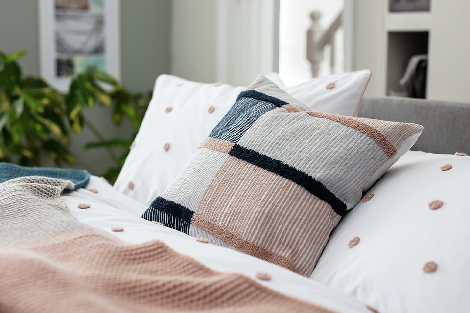 Patterned cushion on bed.