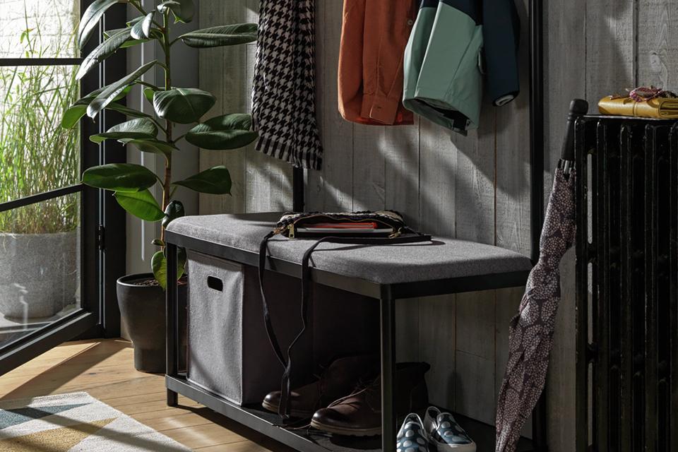 A black hallway tree with storage space for coats and shoes.