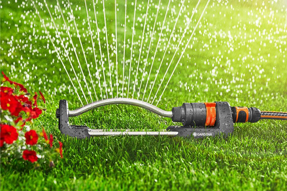 A GARDENA Sprinkler waters a lawn.