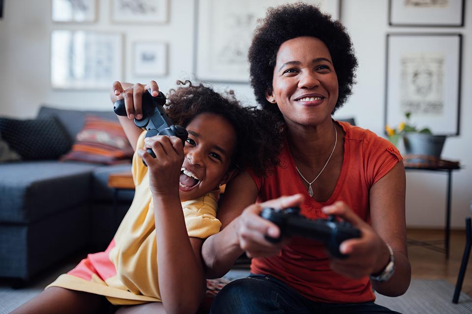 A mother and daughter play videogames.