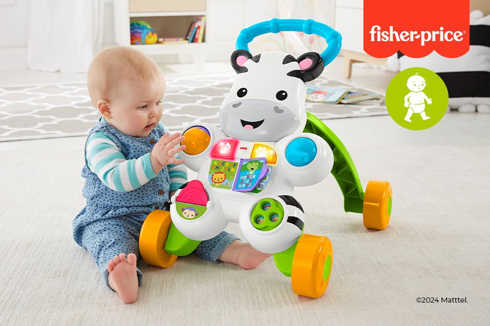 A baby sitting next to a Fisher Price walker.