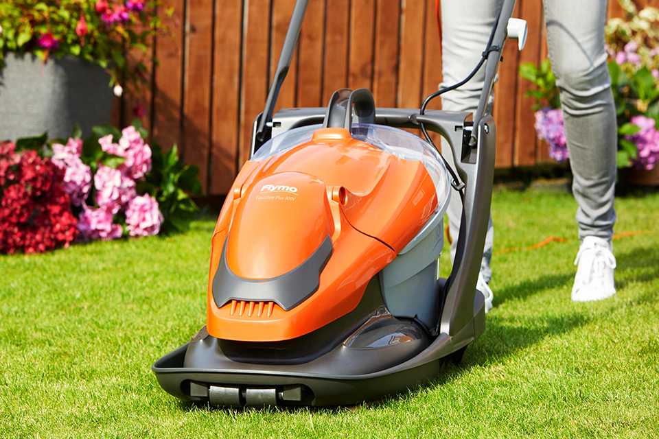 A man mowing a lawn using a Flymo® EasiGlide hover lawnmower.