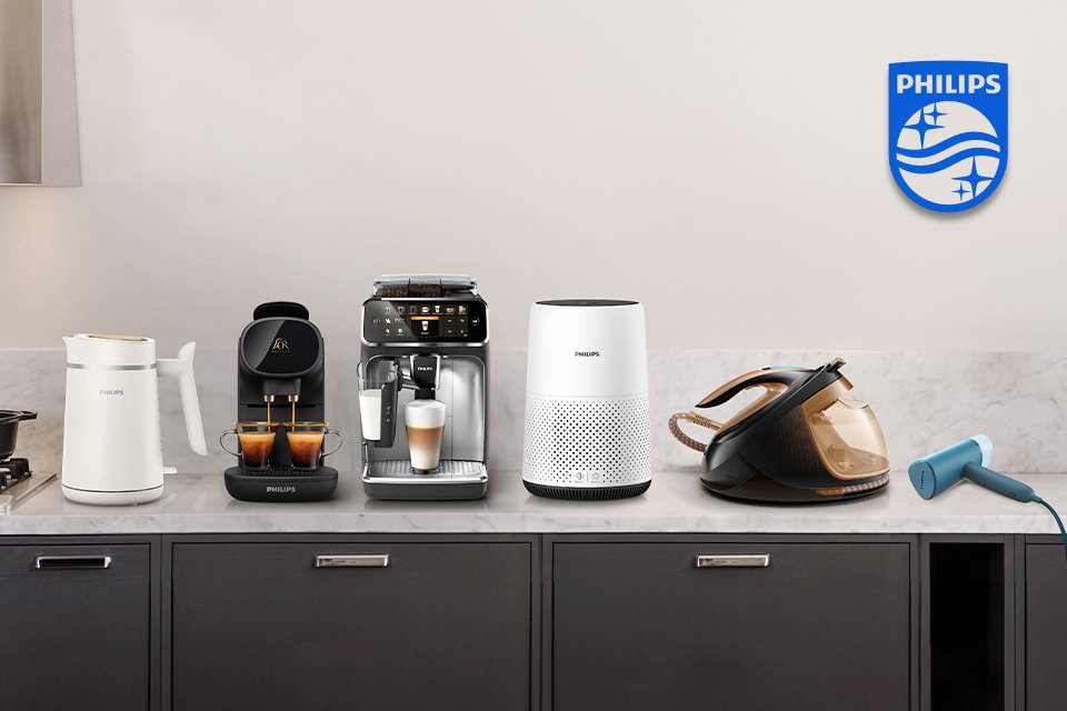 Philips domestic household appliances like coffee machine, iron, cloth steamer and others placed on a shelf.