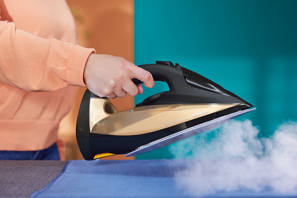 Steam emerging out of a black and gold Philips iron.