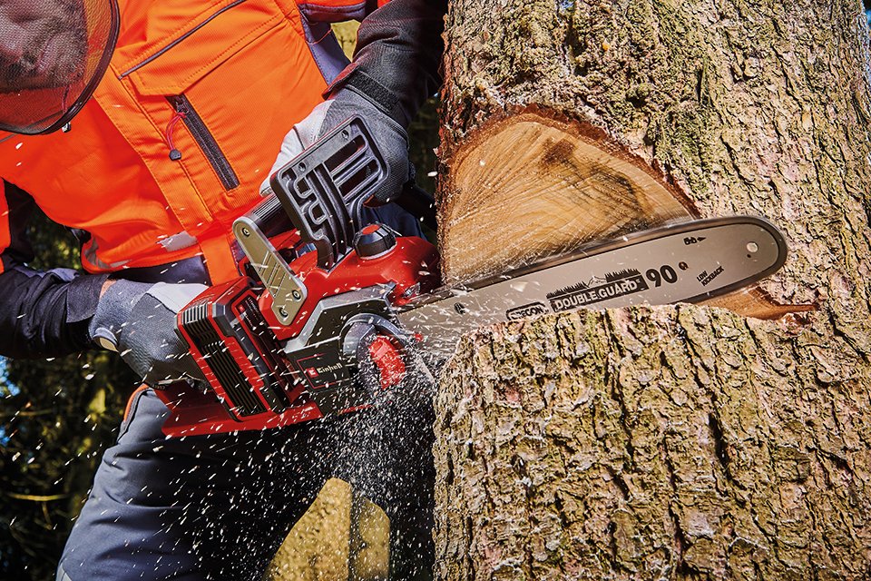 A person using Einhell cordless chainsaw to cut wood.