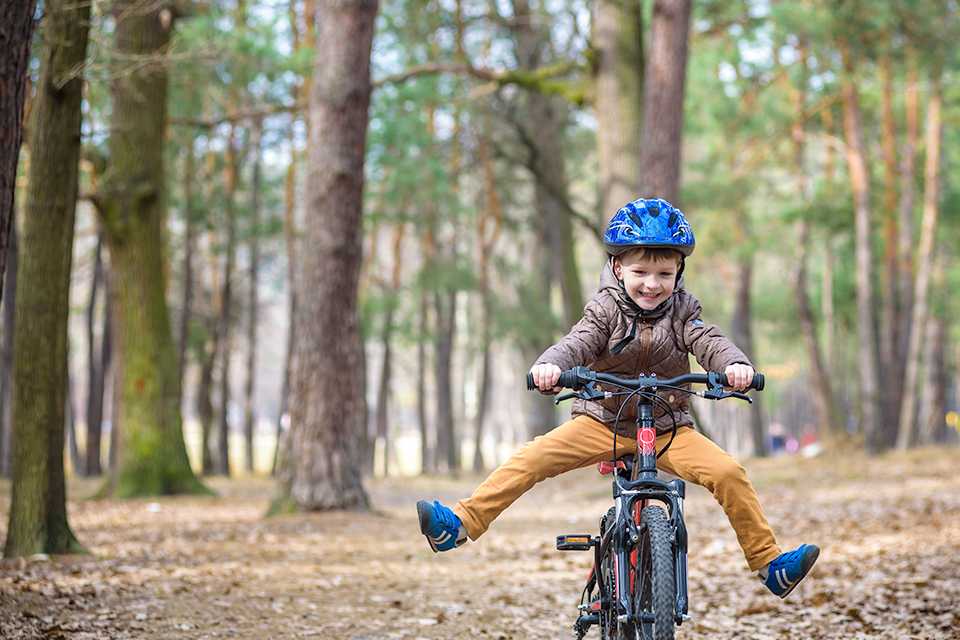 A kid riding a bike on a off-road trail.