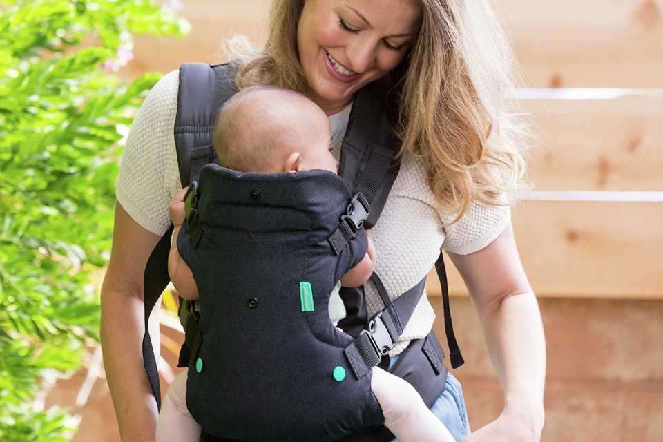 A newborn baby in a baby carrier.