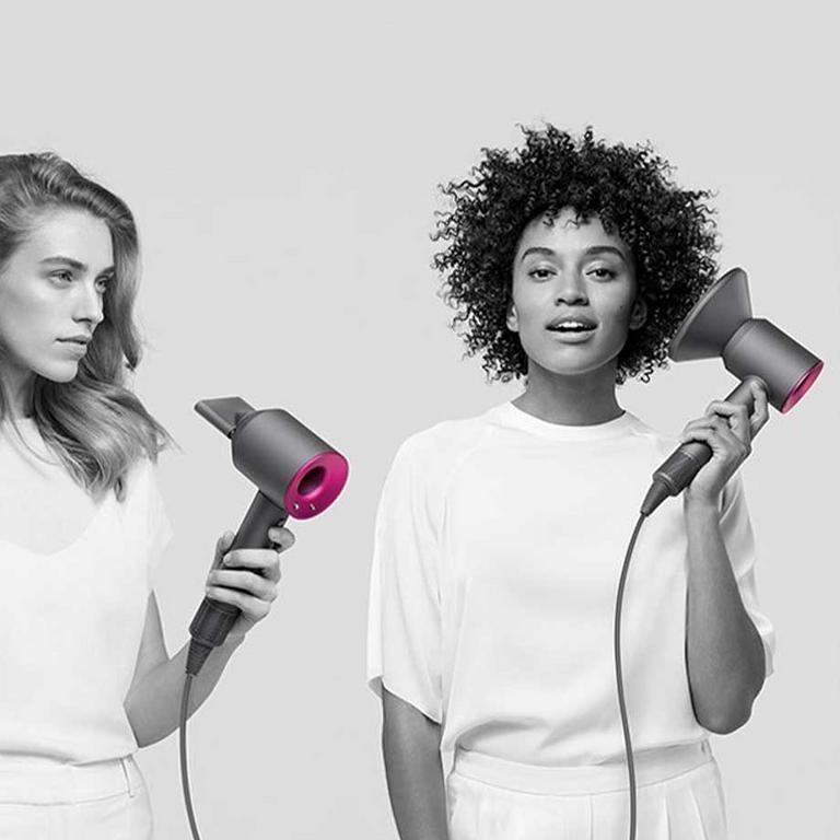 Two women using the Dyson Supersonic hair dryer.