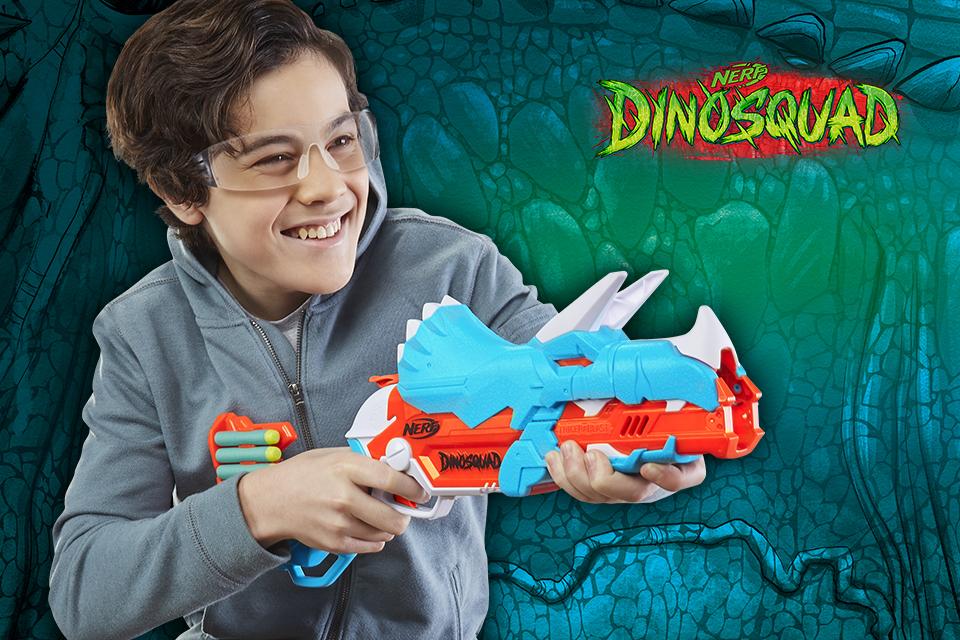 A young boy wearing safety goggles and holding a Nerf DinoSquad blaster.
