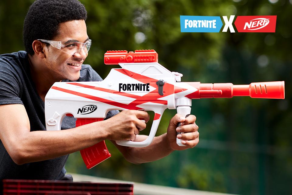 A boy wearing safety goggles and holding a Nerf Fortnite blaster.