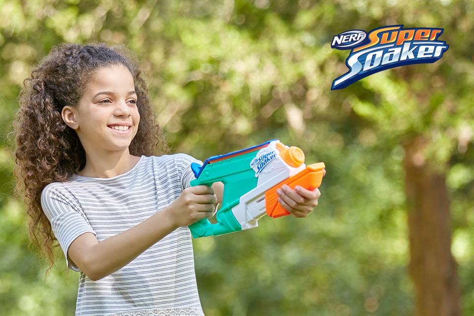 A young girl holding a Nerf Super Soaker water blaster.