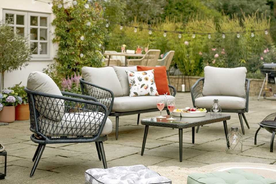 A beautiful garden with a 4-seater rattan garden sofa set.