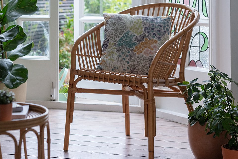 A colourful cushion sitting on a chair.