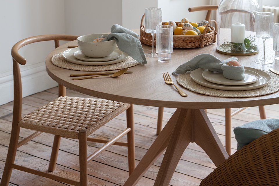 A round dining table in brown colour.