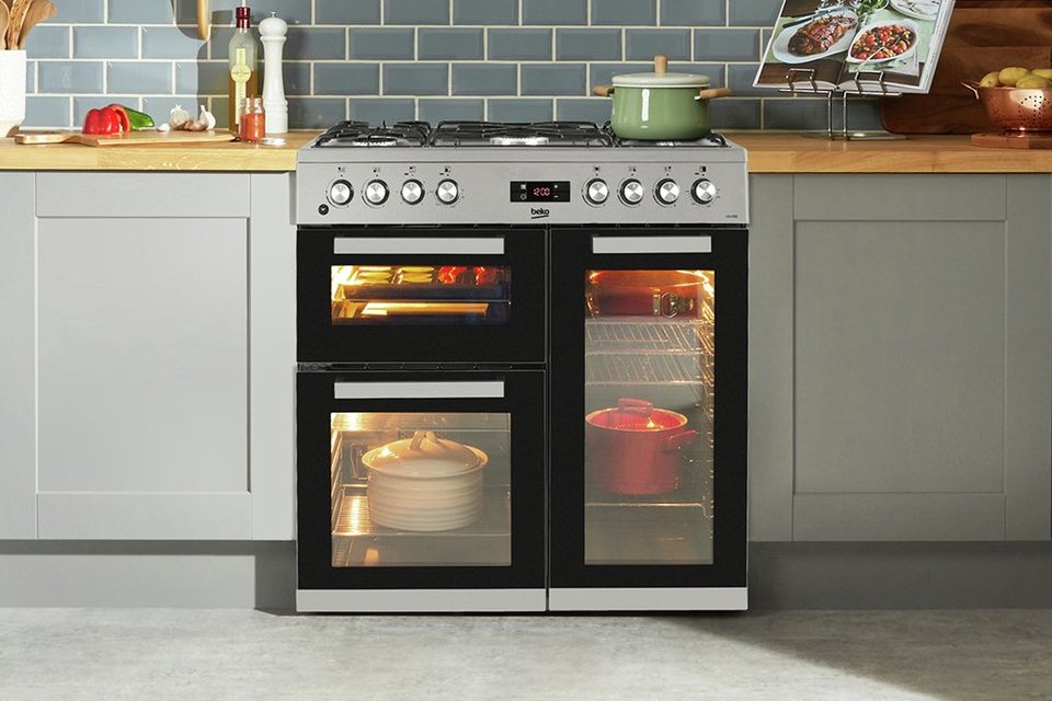 Beko 90cm stainless steel dual fuel range cooker in a kitchen setup.